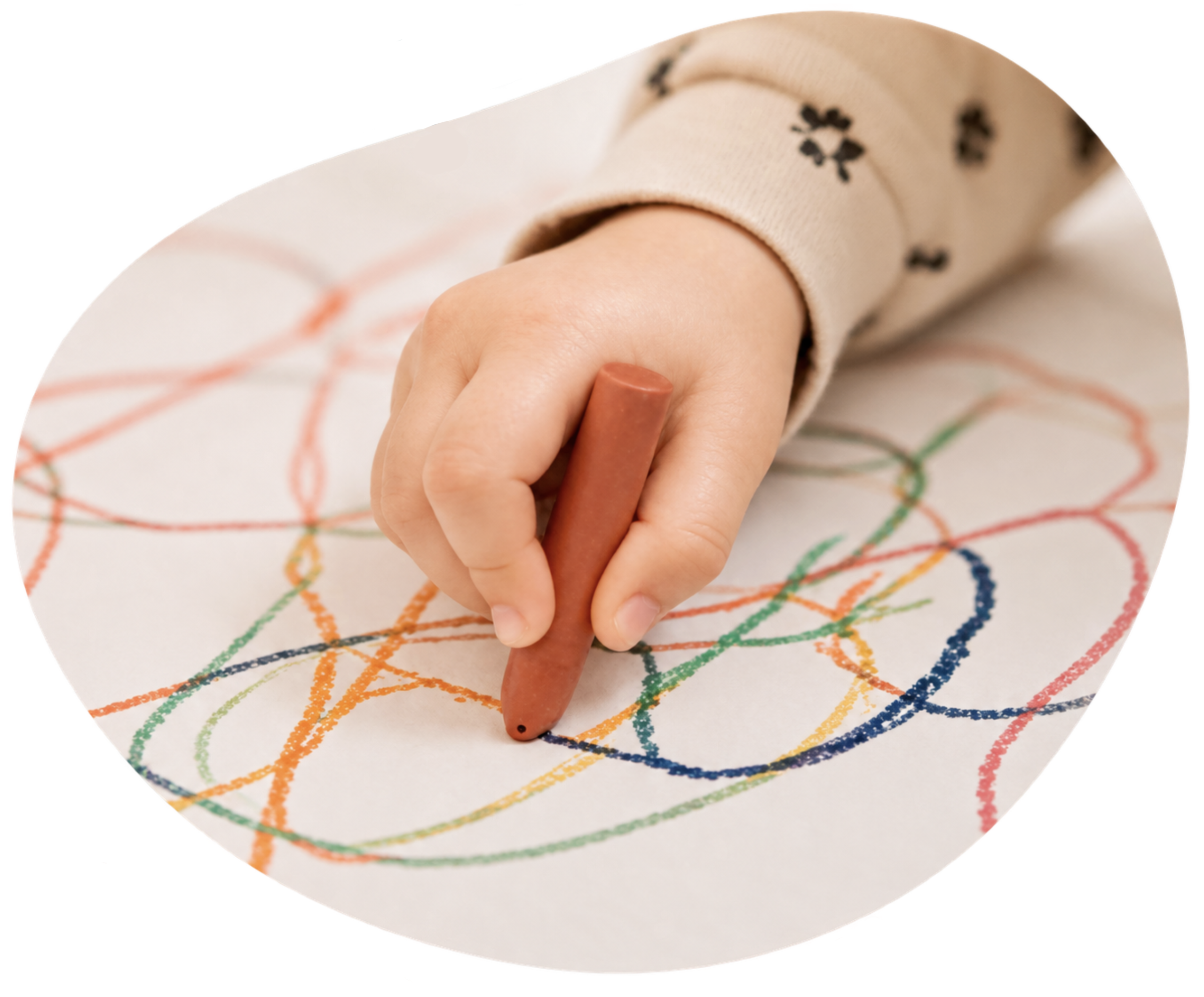 A young child’s hand, scribbling with a crayon.